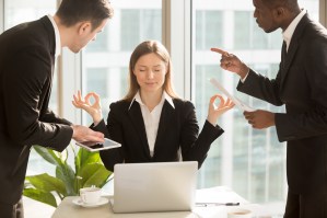 Beautiful businesswoman meditating at workplace, ignoring work a