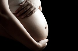 pregnant asian woman on black background