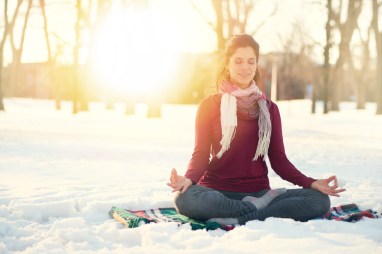 Attractive mixed race woman doing yoga in nature at winter time