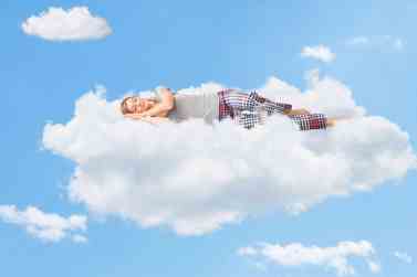 Tranquil scene of a woman sleeping on cloud
