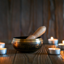 singing bowl on dark wooden background. Burning candles and oil for aromatherapy and massage..